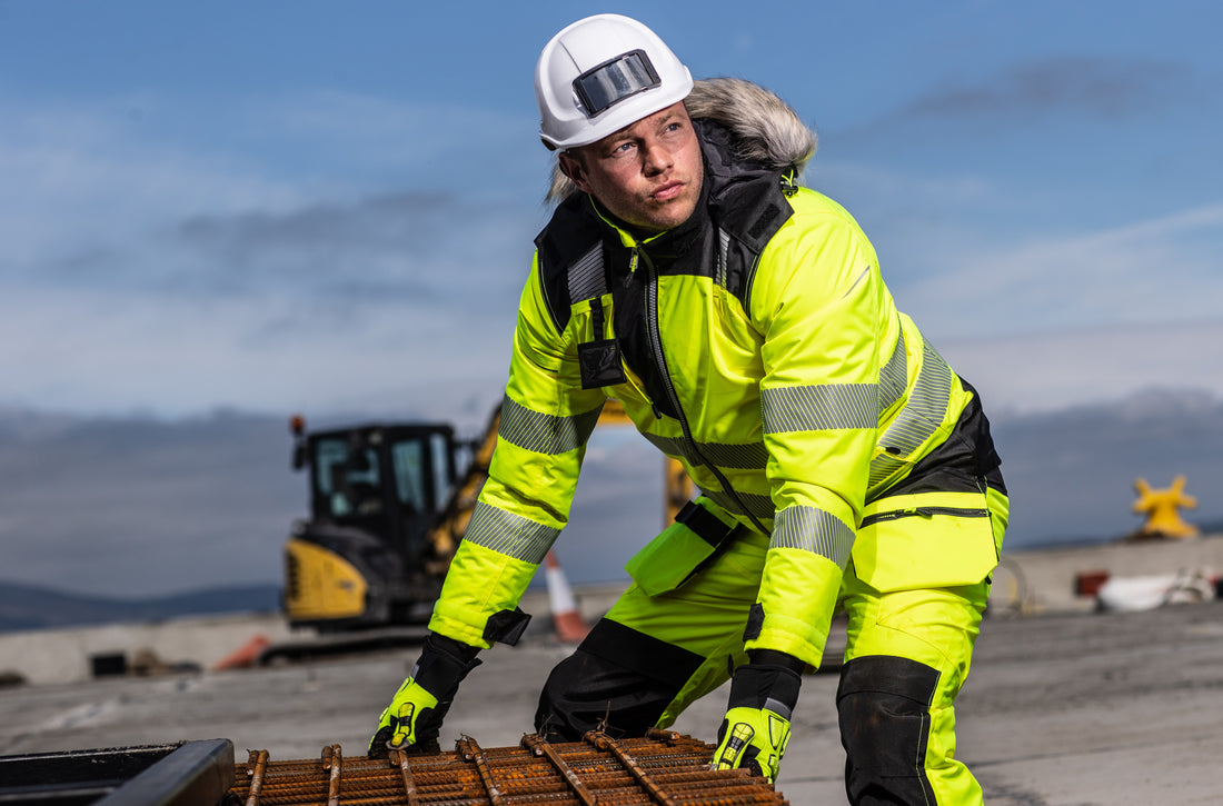 Ouvrier en parka d'hiver haute visibilité PW369 et pantalon PW351 sur un chantier